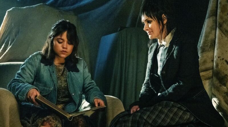 Jenna Ortega reads a book next to Winona Ryder in Beetlejuice Beetlejuice.